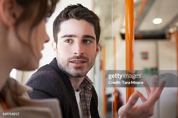 man talking to woman in train - selective focus imagens e fotografias de stock