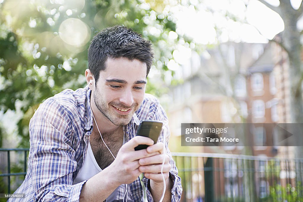 Man smiling with earphones and mobile