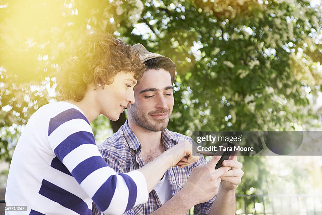 Man and woman texting in park