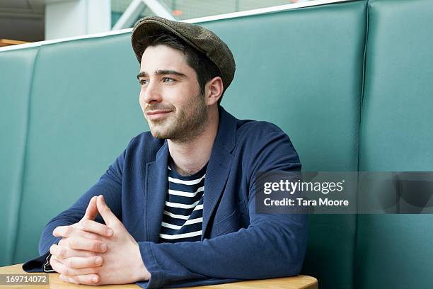 man sitting in cafe - flat cap stock pictures, royalty-free photos & images