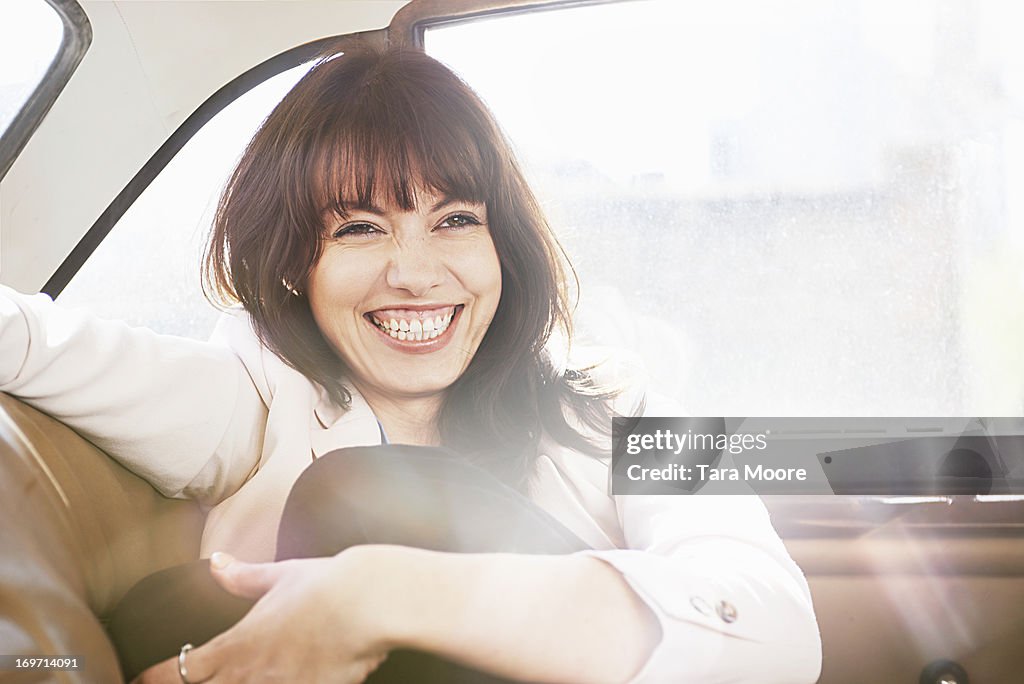 Woman laughing in vintage car