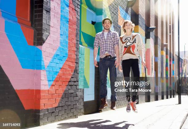 man and woman jumping in street - drifting stock-fotos und bilder