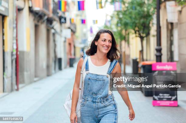 happy caucasian woman walking through the city center looking to the side - mirar alrededor fotografías e imágenes de stock