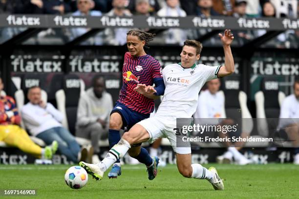 Xavi Simons of RB Leipzig is challenged by Max Woeber of Borussia Moenchengladbach during the Bundesliga match between Borussia Mönchengladbach and...