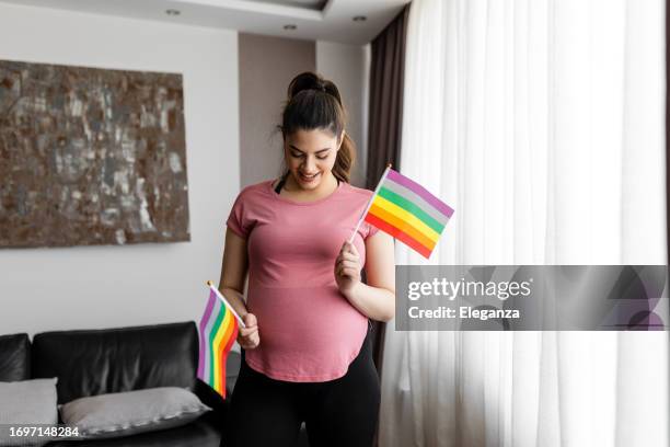 pregnant woman with rainbow flag - lesbian couple green stock pictures, royalty-free photos & images