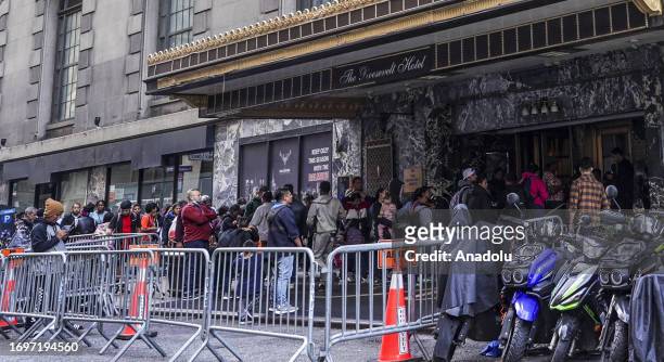 Asylum seekers line up in front of the historic Roosevelt Hotel, converted into a city-run shelter for newly arrived migrant families in New York...