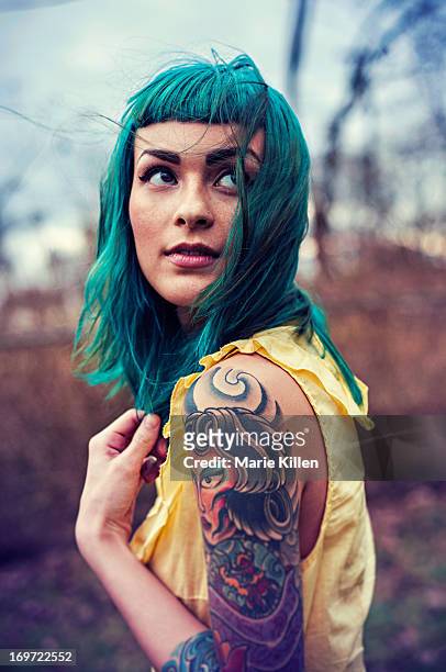 girl with blue hair and tattoos looking over - tatuaje fotografías e imágenes de stock