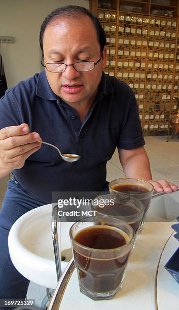 Gerardo De Leon, marketing manager for a federation of coffee-growing cooperatives in Guatemala, prepares to taste several different coffee roasts...