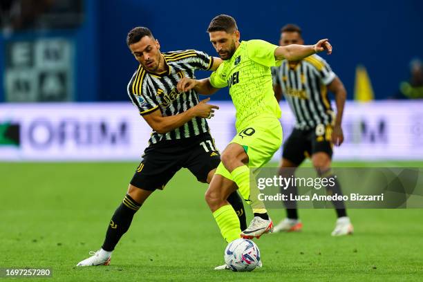 Domenico Berardi of U.S. Sassuolo Calcio competes for the ball with Filip Kostić of Juventus FC during the Serie A TIM match between US Sassuolo and...