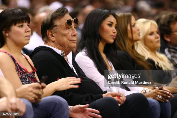Team owner Donald Sterling of the Los Angeles Clippers and V. Stiviano watch the San Antonio Spurs play against the Memphis Grizzlies during Game One...
