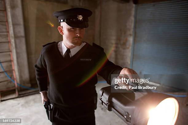 security guard shining flashlight into bunker - police flashlight stock pictures, royalty-free photos & images