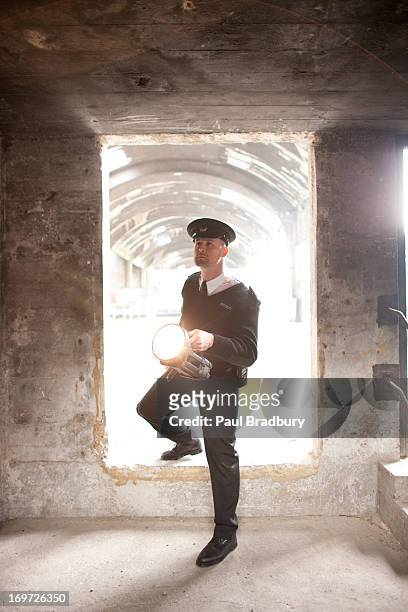 security guard with flashlight checking bunker - police flashlight stock pictures, royalty-free photos & images