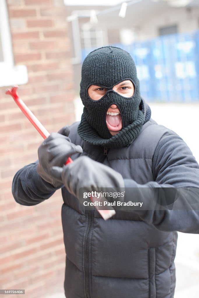 Burglar in ski mask wielding crowbar