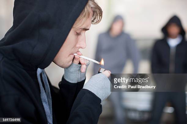 hombre iluminación cigarrillo de marihuana - marijuana joint fotografías e imágenes de stock