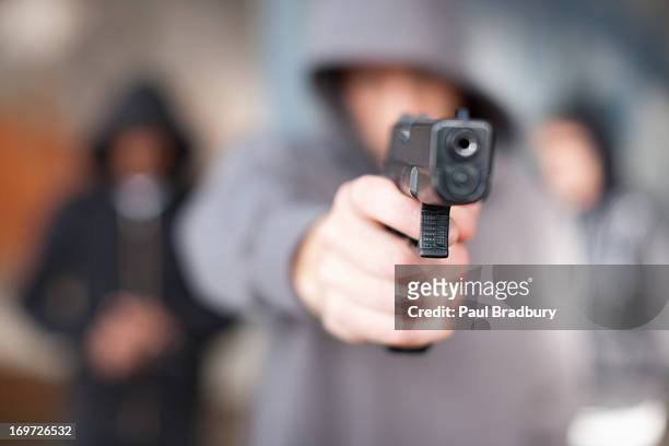 man with gun pointed at viewer - gang of outlaws in concert stockfoto's en -beelden