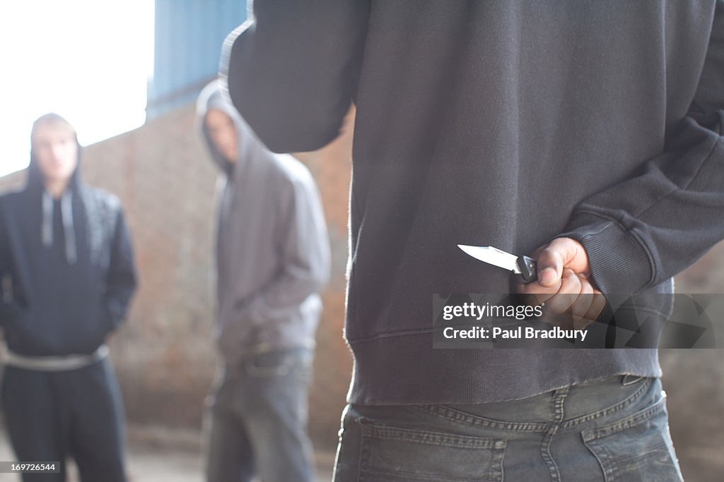 Two men being confronted by man with knife