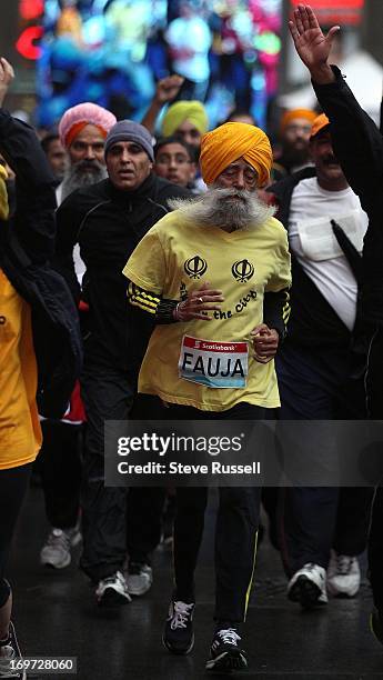 Fauja Singh runs up to the finish line at the Scotiabank Toronto Waterfront Marathon 5 k in Toronto.