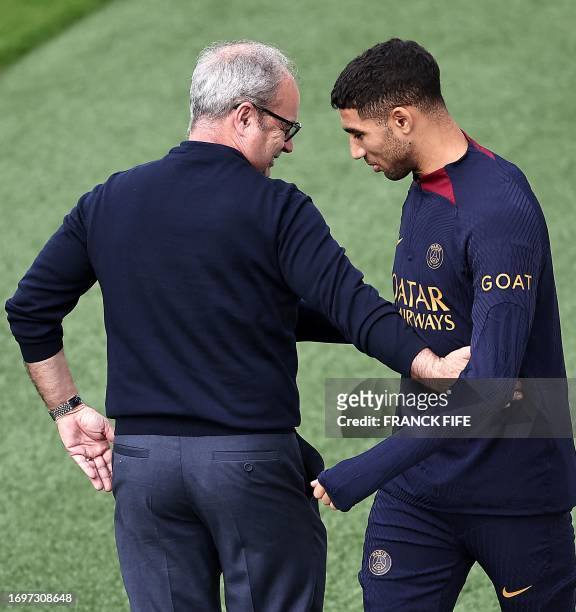 Paris Saint-Germain's Moroccan defender Achraf Hakimi speaks with Paris Saint Germain's Portuguese football Advisor Luis Campos before a training...