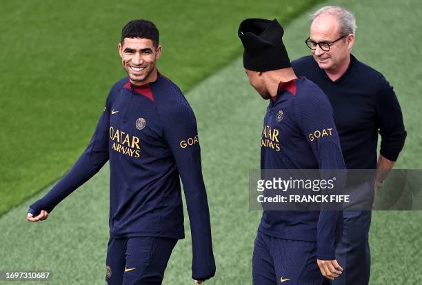 Paris Saint-Germain's French forward Kylian Mbappe and Paris Saint-Germain's Moroccan defender Achraf Hakimi speaks with Paris Saint Germain's...