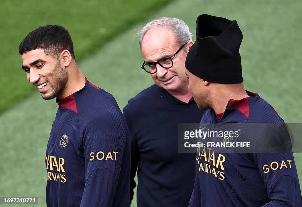 Paris Saint-Germain's French forward Kylian Mbappe and Paris Saint-Germain's Moroccan defender Achraf Hakimi speaks with Paris Saint Germain's...