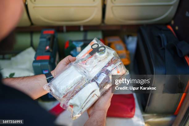 driver is checking first aid kit in the boot. - auto-ongeluk stockfoto's en -beelden