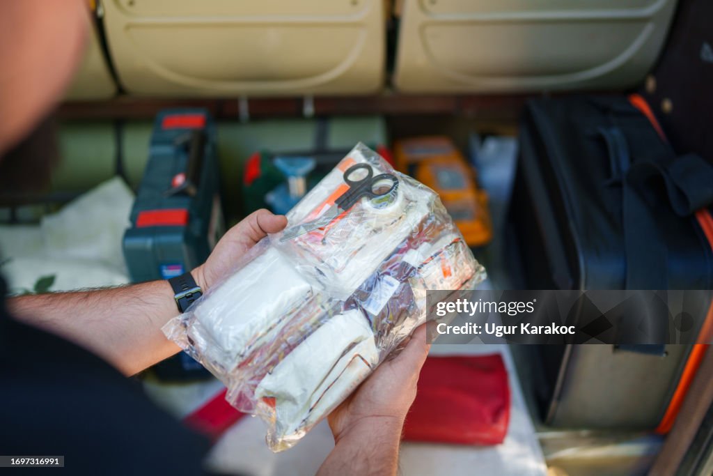 Driver is checking first aid kit in the boot.