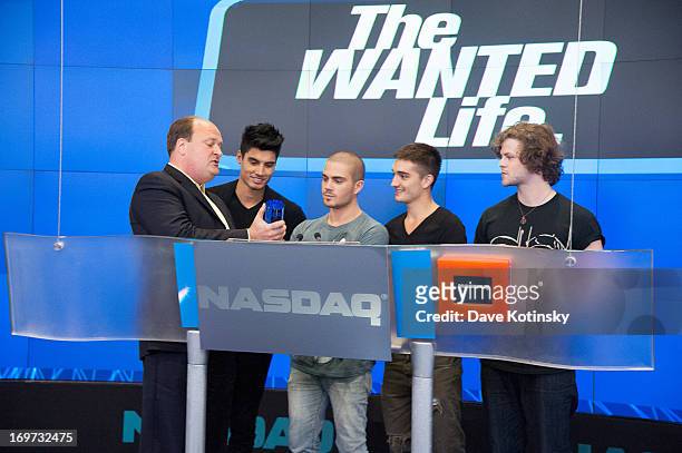 Tom Parker, Max George, Jay McGuiness and Siva Kaneswaran of the band The Wanted rings The NASDAQ Stock Market Closing Bell at NASDAQ MarketSite on...