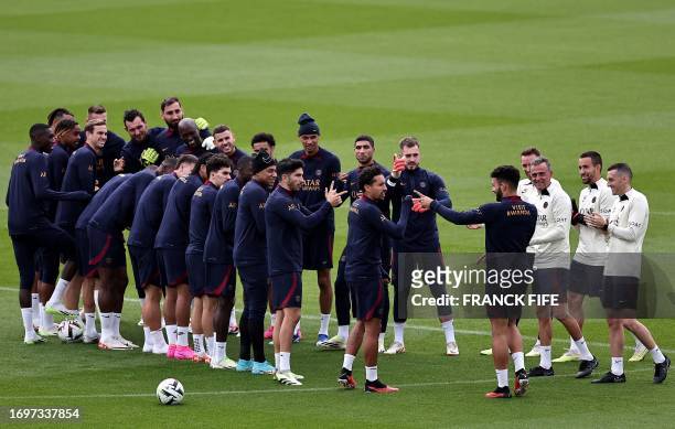 Paris Saint-Germain's Portuguese forward Goncalo Ramos reacts with Paris Saint-Germain's players during a training session at Poissy, west of Paris...
