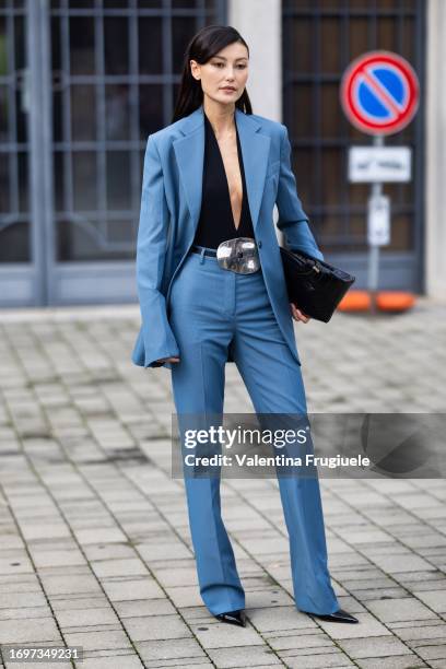 Amalie Gassmann is seen wearing a black leather Ferragamo bag, black pumps, a silver belt, a black v-neck top and a light blue suit outside the...