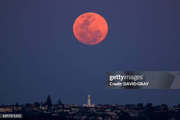 The full moon, a supermoon also known as the "Harvest Moon", rises over Macquarie Lighthouse in Sydney on September 29, 2023.