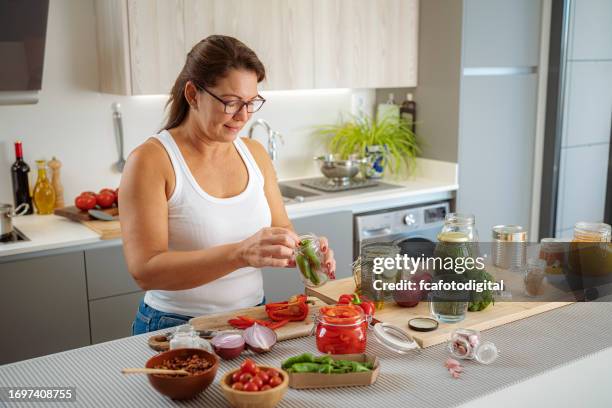 woman pickles and cans vegetables in glass jars - i was turning into a vegetable stock pictures, royalty-free photos & images
