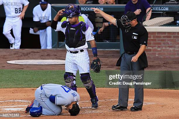 Luis Cruz of the Los Angeles Dodgers falls to the ground after being hit by a pitch by Jon Garland of the Colorado Rockies as catcher Wilin Rosario...