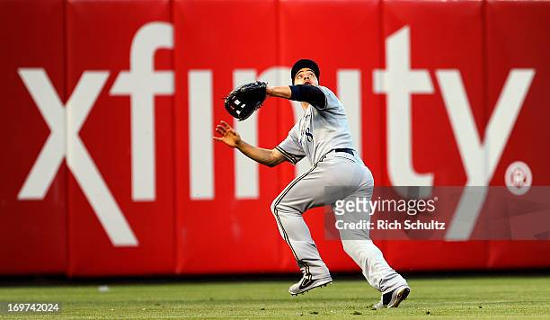 Left fielder Ryan Braun of the Milwaukee Brewers goes back after misjudging a fly ball hit by Freddy Galvis of the Philadelphia Phillies during the...