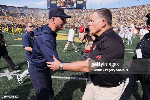 Head coach Jim Harbaugh of the Michigan Wolverines shakes hands with head coach Greg Schiano of the Rutgers Scarlet Knights after a 31-7 Michigan win...