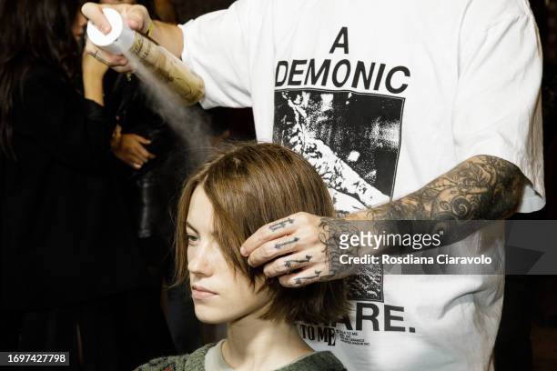 Model and hairdresser backstage ahead of the Sportmax fashion show during the Milan Fashion Week Womenswear Spring/Summer 2024 on September 22, 2023...