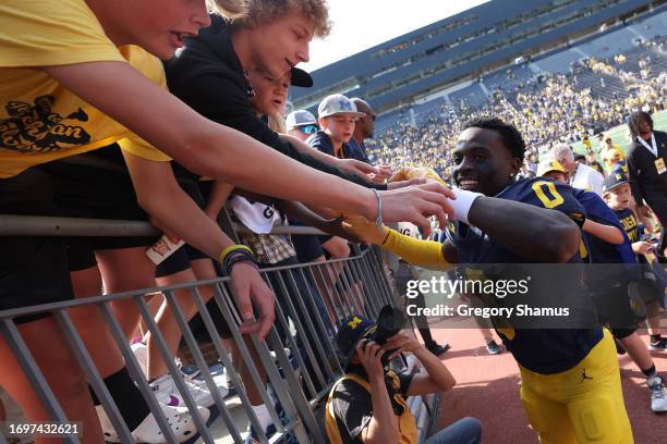 Mike Sainristil of the Michigan Wolverines celebrates a 31-7 win over the Rutgers Scarlet Knights with fans at Michigan Stadium on September 23, 2023...
