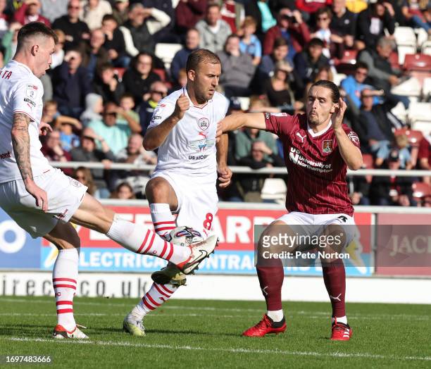 Ben Fox of Northampton Town contests the ball with Kacper Lopata and Herbie Kane of Barnsley during the Sky Bet League One match between Northampton...