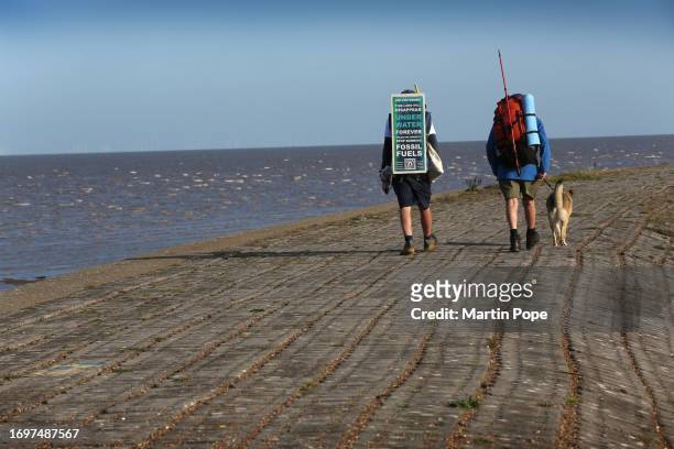 Dr Charlie Gardner is joined for a few days on his walk by Robert Possnett and Lola as they walk along sea defences near Heacham during a walk to...