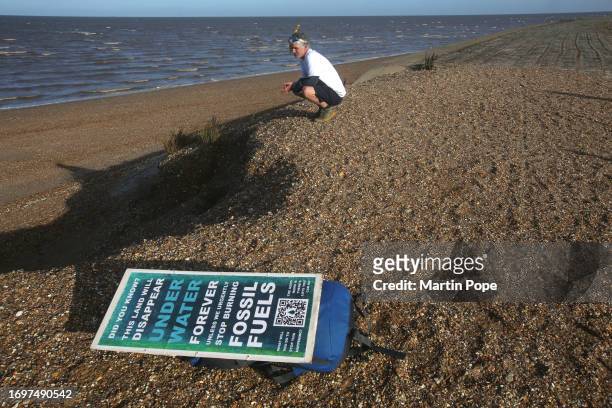 Dr Charlie Gardner looks at a patch land erosion next to concrete sea defences during a walk to highlight climate change on September 29, 2023 in...