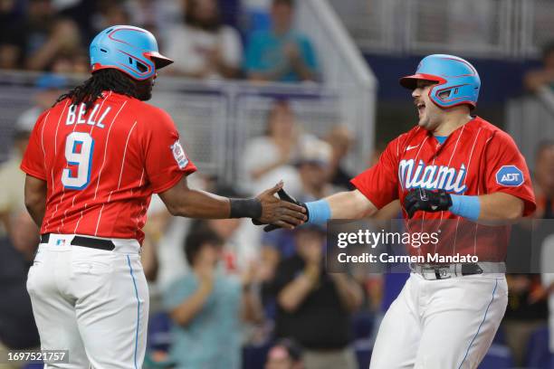 Jake Burger of the Miami Marlins high fives Josh Bell after hitting a three run home run during the first inning against the Milwaukee Brewers at...