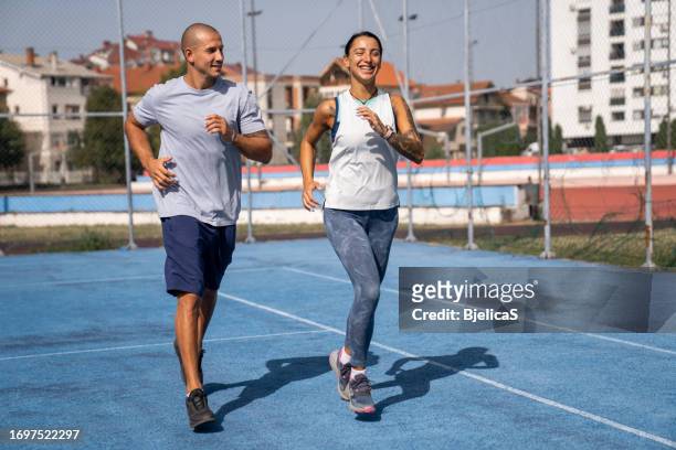夏の日に一緒にジョギングする若い夫婦 - s motive season two ストックフォトと画像