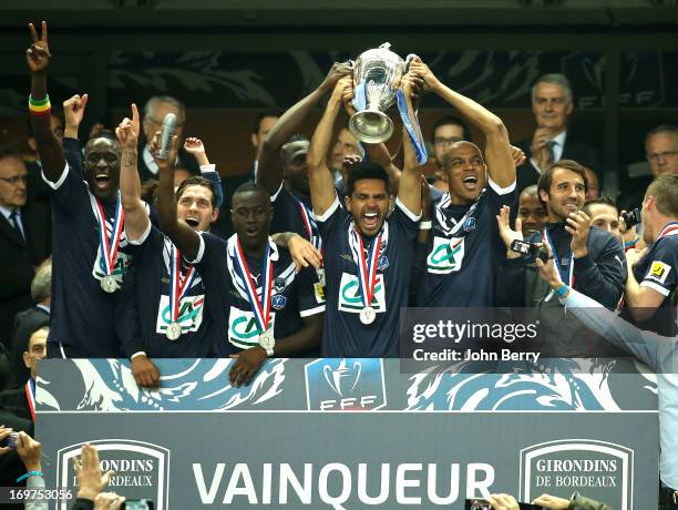 Benoit Tremoulinas and Carlos Henrique lift the winners trophy with their teammates Ludovic Sane, Henri Saivet, Marc Planus after the French Cup...