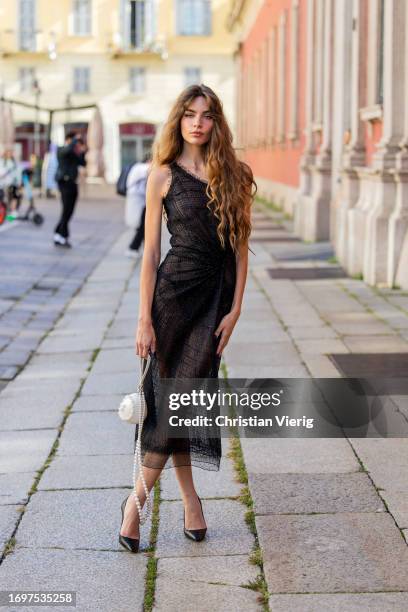 Mara Lafontan wears black transparent dress, white bag outside Ermanno Scervino during the Milan Fashion Week - Womenswear Spring/Summer 2024 on...