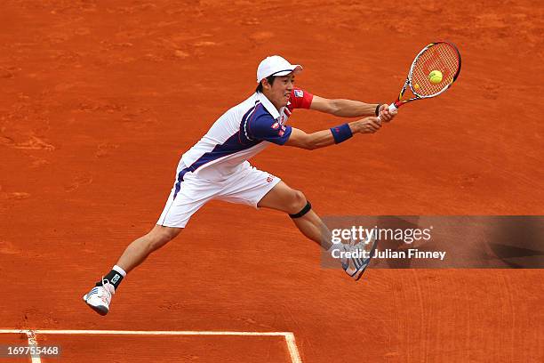 Kei Nishikori of Japan plays a backhand during his Men's Singles match against Benoit Paire of France on day seven of the French Open at Roland...