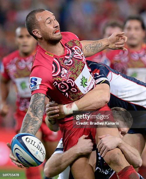 Quade Cooper of the Reds offloads during the round 16 Super Rugby match between the Reds and the Rebels at Suncorp Stadium on June 1, 2013 in...