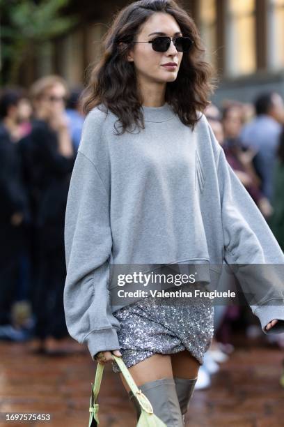 Diletta Bonaiuti is seen wearing a silver paillettes mini skirt, high grey boots and wide grey sweater outside The Attico show during the Milan...