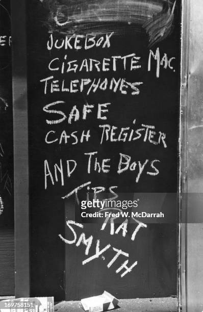 Close-up of handwritten chalk text on a boarded-up window of the Stonewall Inn after riots over the weekend of June 27, 1969. The text reads...