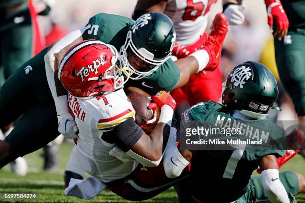 Antwain Littleton II of the Maryland Terrapins is tackled by Jordan Hall and Jaden Mangham of the Michigan State Spartans in the second quarter of a...