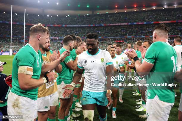 Siya Kolisi of South Africa leads players of South Africa off the field through a guard of honour formed by players of Ireland after defeat during...