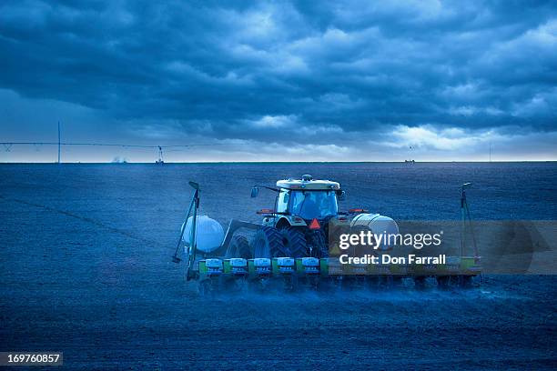 planting corn, rain approaching - tractor planting corn stock pictures, royalty-free photos & images